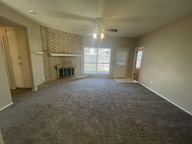 an empty room with windows and fireplace