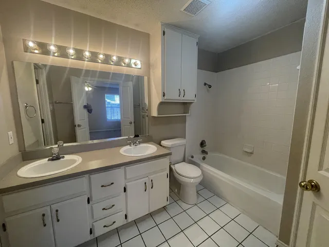a bathroom with a double vanity sink mirror and toilet