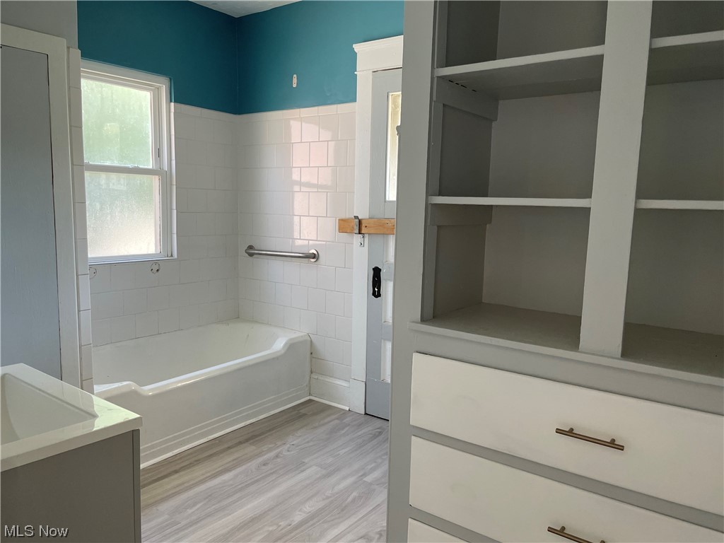 1730 Burgess Road Cleveland, OH 44112 - Photo 9 of 35 Bathroom featuring light grey LVT flooring, bathtub, and storage cabinet
