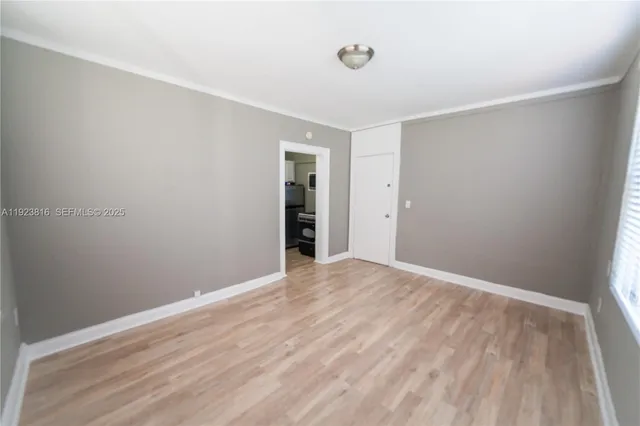 a view of an empty room with wooden floor