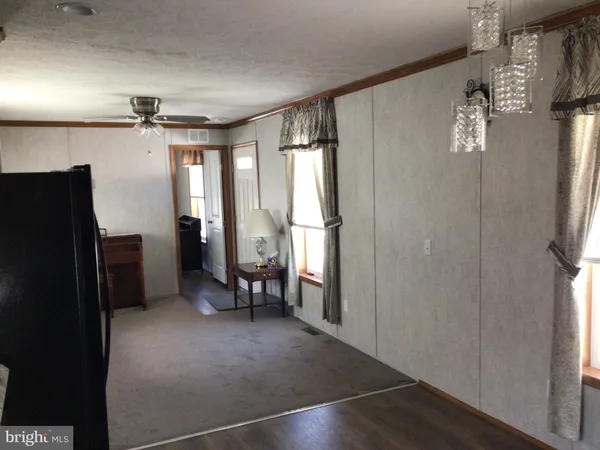 a view of hallway with furniture and a refrigerator