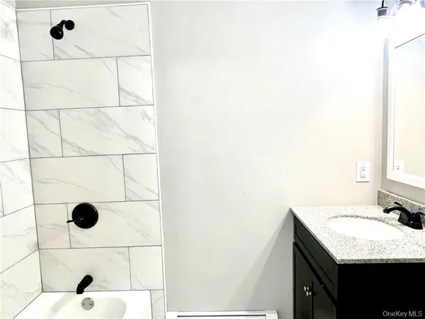 a bathroom with a granite countertop shower and a sink