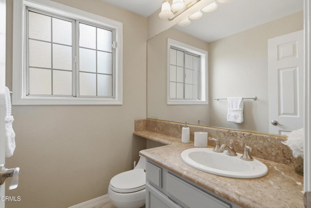 11543 Ragusa Drive Rancho Cucamonga, CA 91701 - Photo 29 of 69 a bathroom with a toilet a sink a mirror and a window