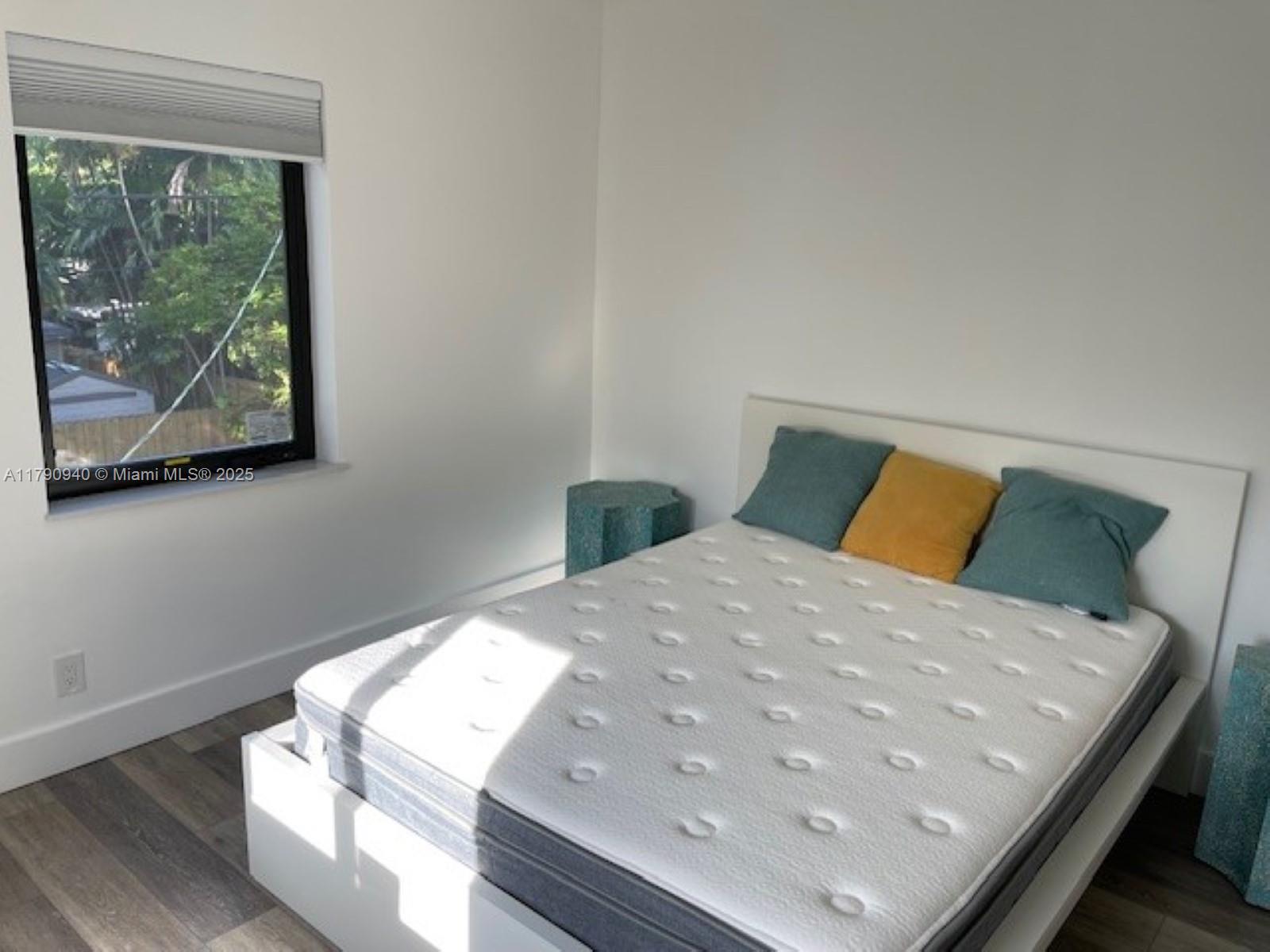 2141 Southwest 14th Terrace, Unit 4 Miami, FL 33145 - Photo 8 of 15 a bed sitting in a bedroom next to a window