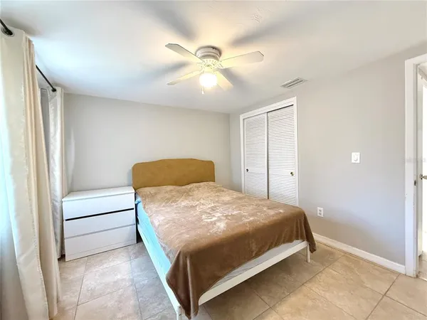 a bedroom with a bed and a ceiling fan