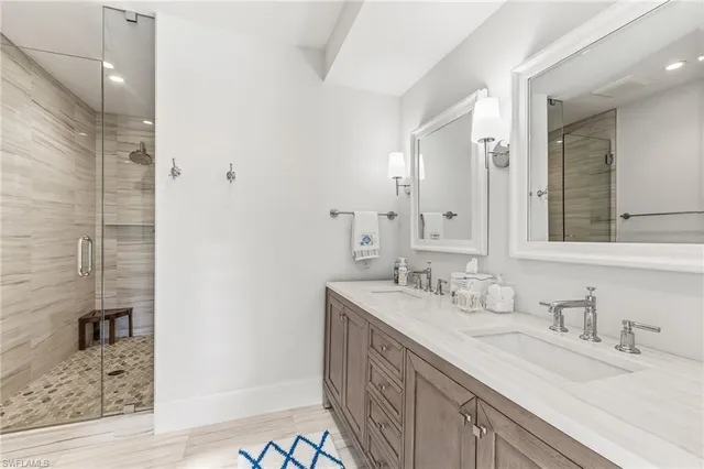 a bathroom with a double vanity sink mirror and shower