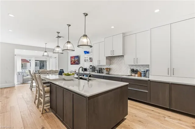 a kitchen with stainless steel appliances granite countertop a sink a stove and wooden floor
