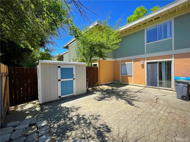 a view of backyard with large trees and wooden fence