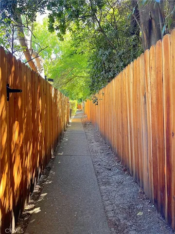 a view of a pathway with a wooden fence