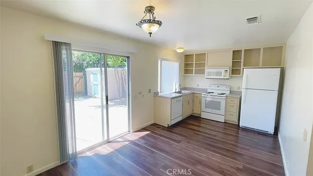 a view of kitchen with wooden floor and electronic appliances