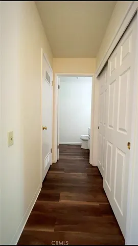 a view of a hallway with wooden floor and stairs