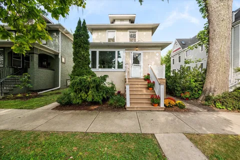 a view of a house with porch and garden