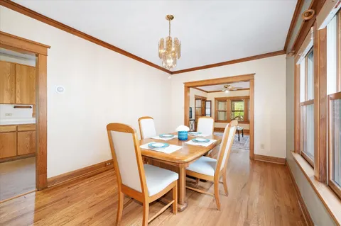 a dining room with furniture a chandelier and wooden floor