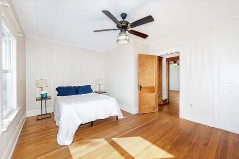 a bedroom with a bed and wooden floor