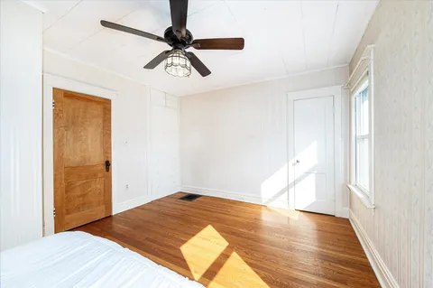 a view of a room with wooden floor and ceiling fan