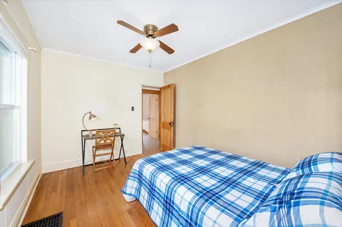 a bedroom with a bed and wooden floor