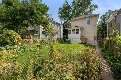 a view of a house with a large tree and a yard