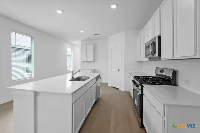 a kitchen with stainless steel appliances granite countertop a sink stove and refrigerator