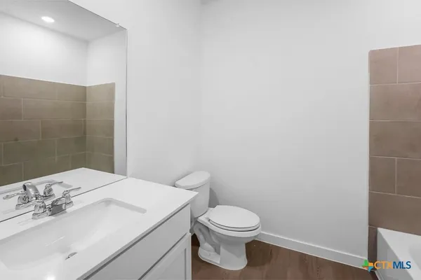 a bathroom with a white toilet and sink