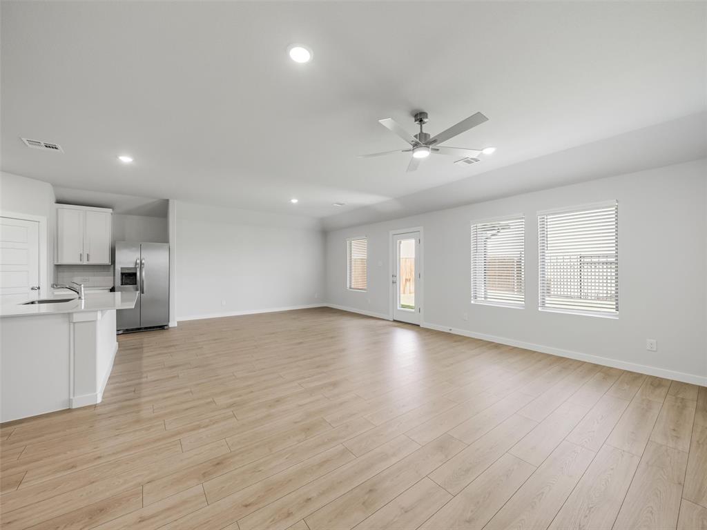 1136 Del Rio Drive Lavon, TX 75166 - Photo 13 of 30 Expansive open-concept living area featuring light wood-finish flooring, recessed lighting, and a modern ceiling fan