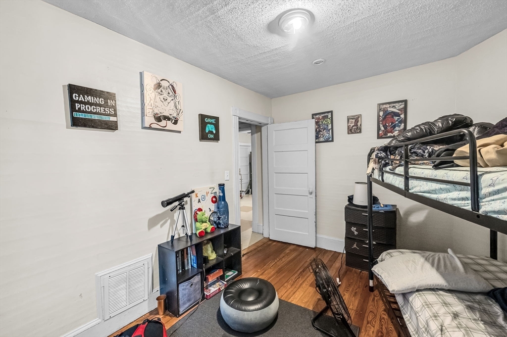 123-125 Ranney Street Springfield, MA 01108 - Photo 14 of 26 a bedroom with a bed and wooden floor