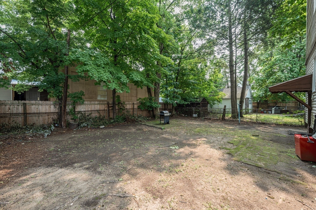 123-125 Ranney Street Springfield, MA 01108 - Photo 25 of 26 a view of a backyard with large trees and wooden fence