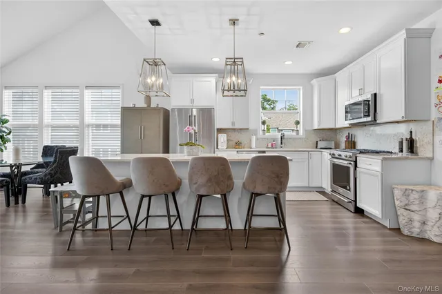 a large kitchen with cabinets table and chairs