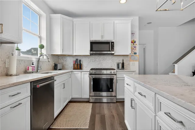 a kitchen with cabinets stainless steel appliances and a sink
