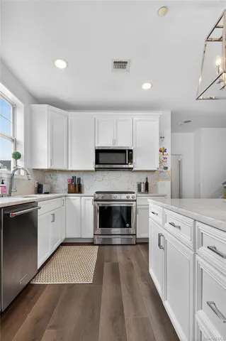 a kitchen with granite countertop white cabinets and white appliances