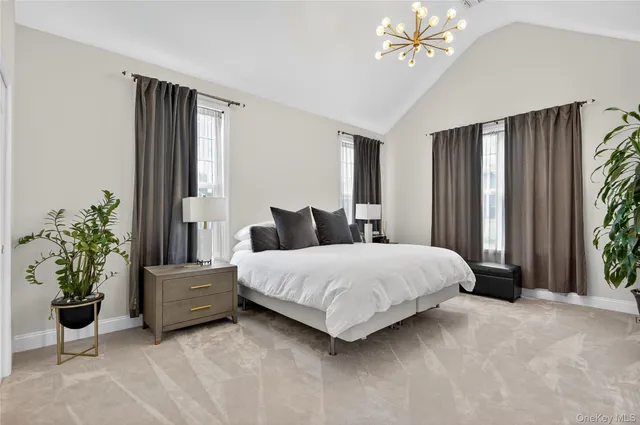 a bedroom with a large bed and a chandelier