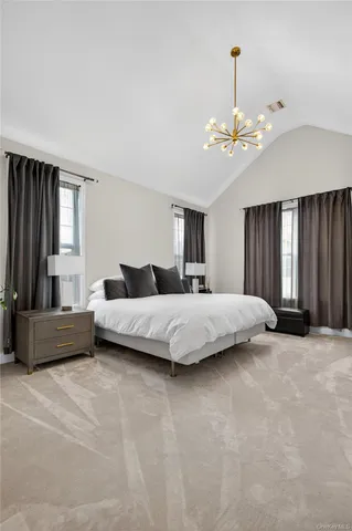 a bedroom with a large bed and a chandelier