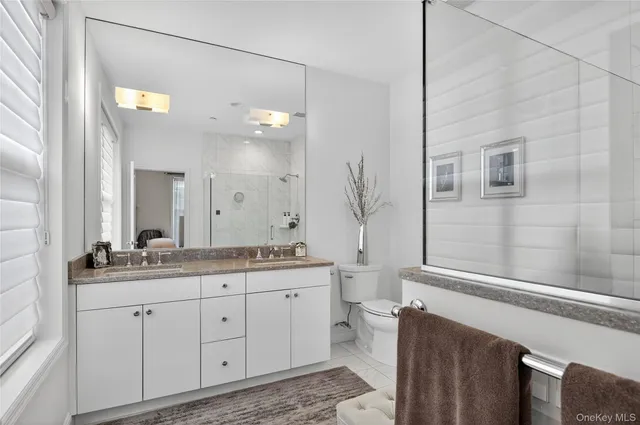 a spacious bathroom with a granite countertop sink a toilet and a mirror