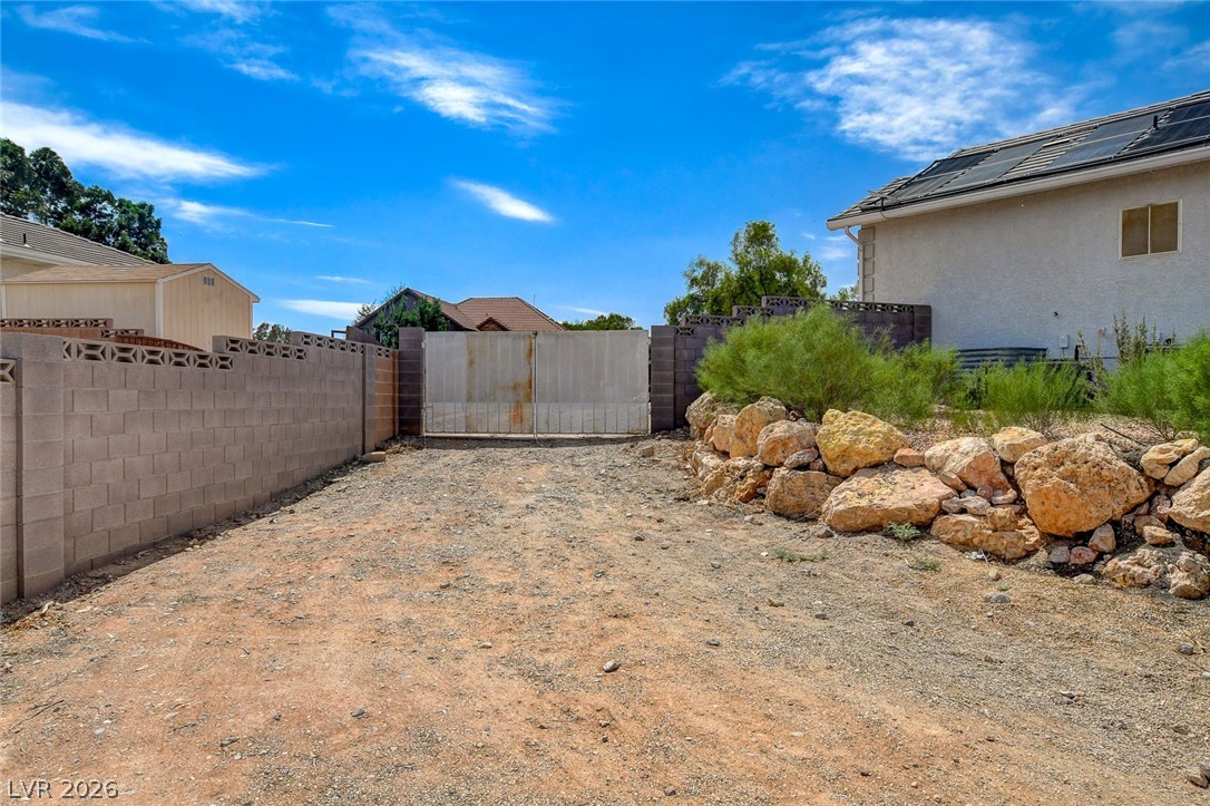 4362 Thistle Street Logandale, NV 89021 - Photo 78 of 99 Secure gated access opens to a private, rock-lined expanse, ideal for expansion.