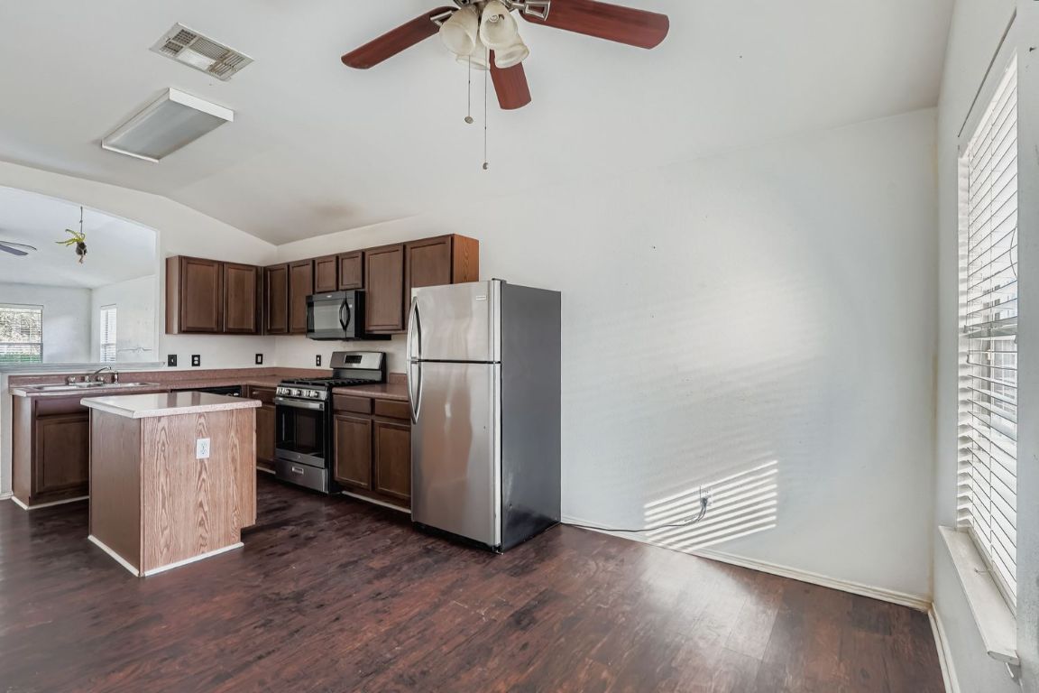 200 Firebush Way Buda, TX 78610 - Photo 13 of 29 a kitchen with stainless steel appliances a refrigerator a stove a sink and a window