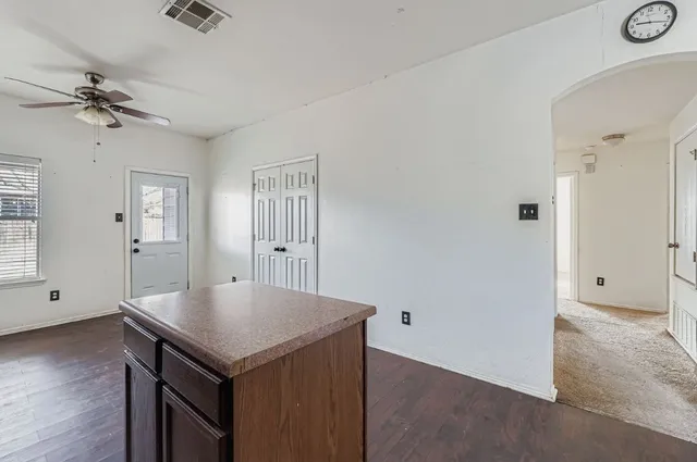an empty room with a window and wooden floor