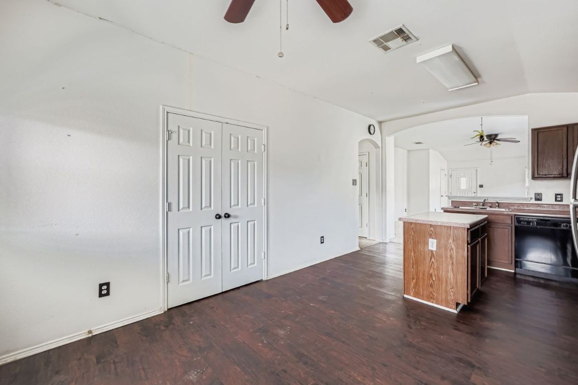 200 Firebush Way Buda, TX 78610 - Photo 15 of 29 a hall with kitchen island wooden floor and ceiling fan