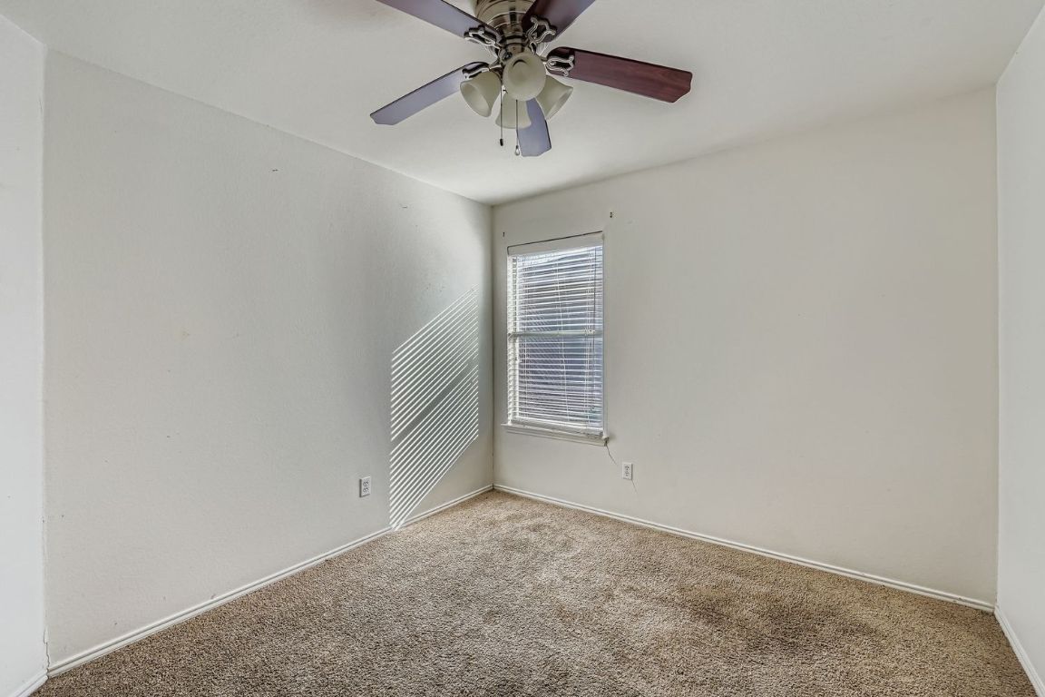 200 Firebush Way Buda, TX 78610 - Photo 21 of 29 an empty room with chandelier fan and windows