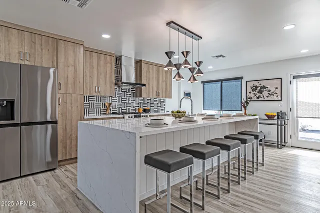 a kitchen with stainless steel appliances granite countertop a refrigerator and a stove top oven