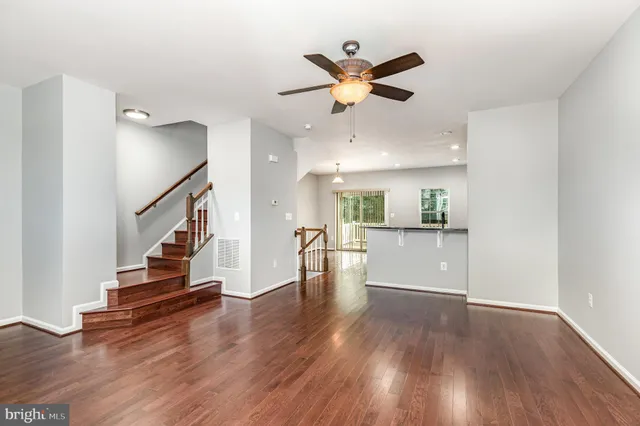 a view of a living room and kitchen with wooden floor