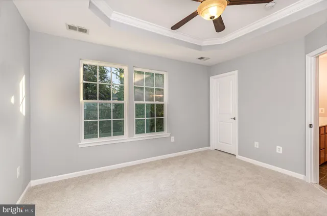 an empty room with window and ceiling fan
