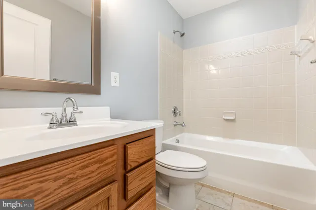 a bathroom with a bathtub shower sink vanity mirror and toilet