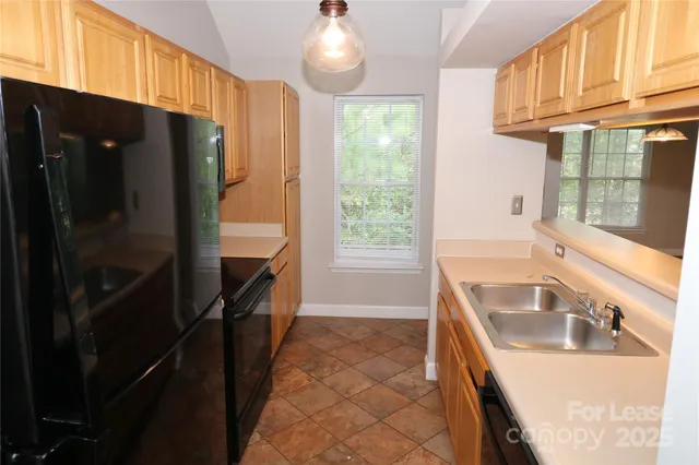 a kitchen with granite countertop a refrigerator and a sink