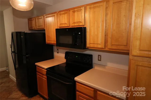 a kitchen with stainless steel appliances granite countertop a refrigerator and a stove top oven