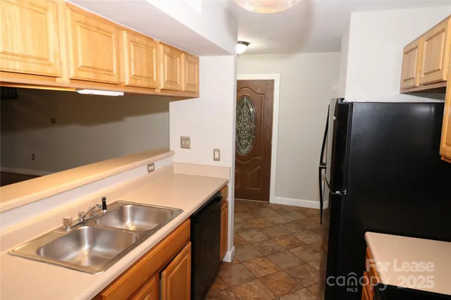 a bathroom with granite countertop a sink and a refrigerator