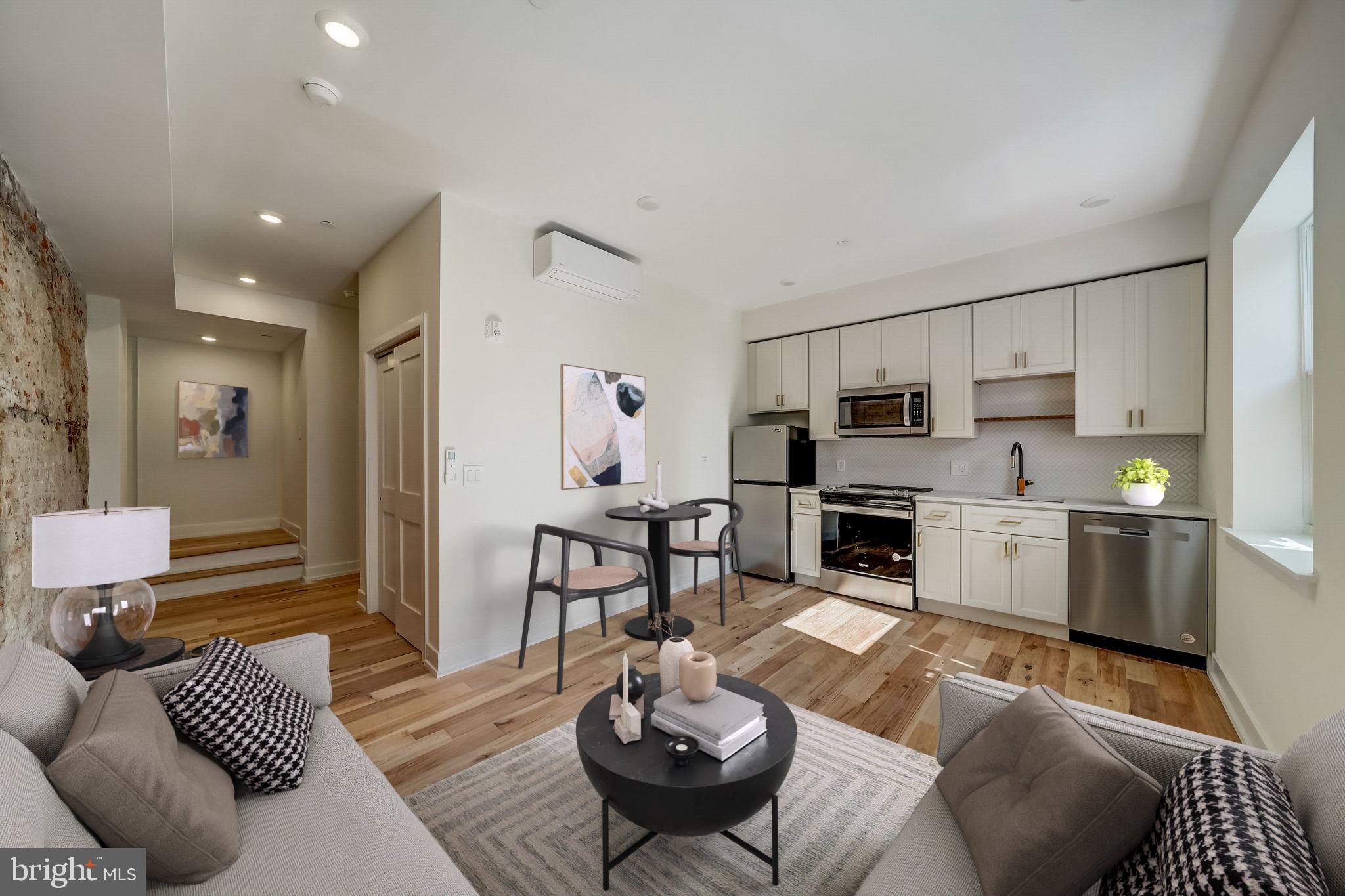 620 South 8th Street Philadelphia, PA 19147 - Photo 4 of 12 a living room with furniture a fireplace and a dining table with kitchen view