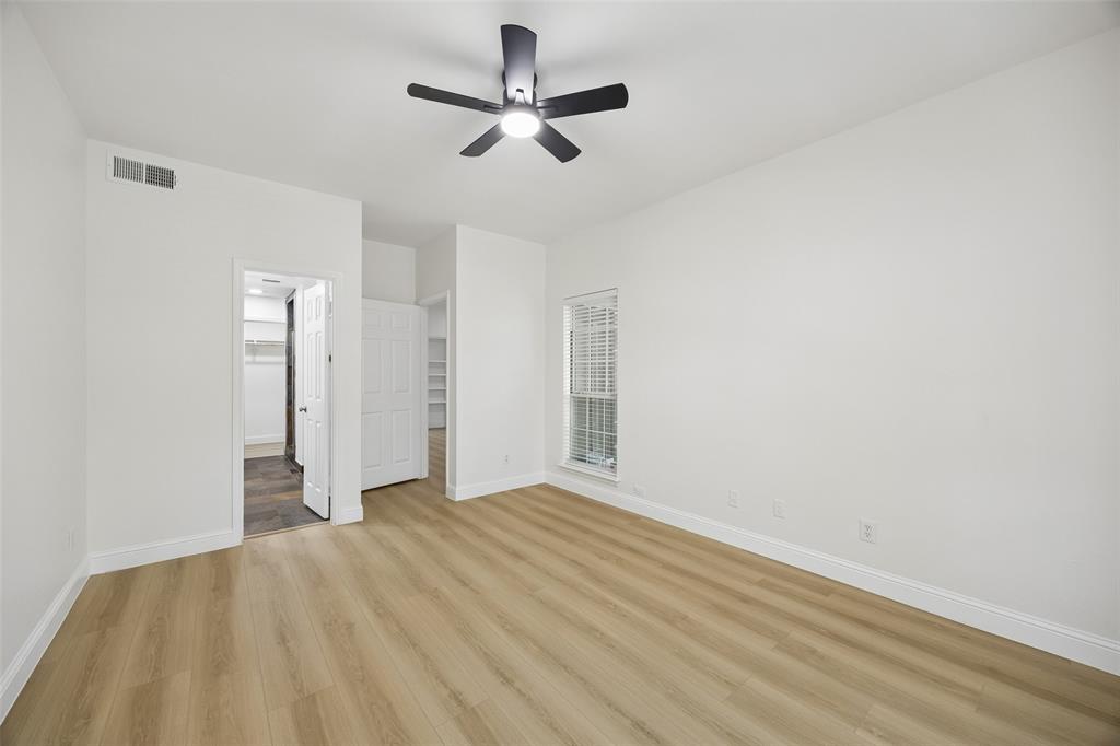 12660 Hillcrest Road, Unit 7205 Dallas, TX 75230 - Photo 4 of 25 Spacious room featuring light wood-finish flooring, white walls, and a ceiling fan with integrated lighting
