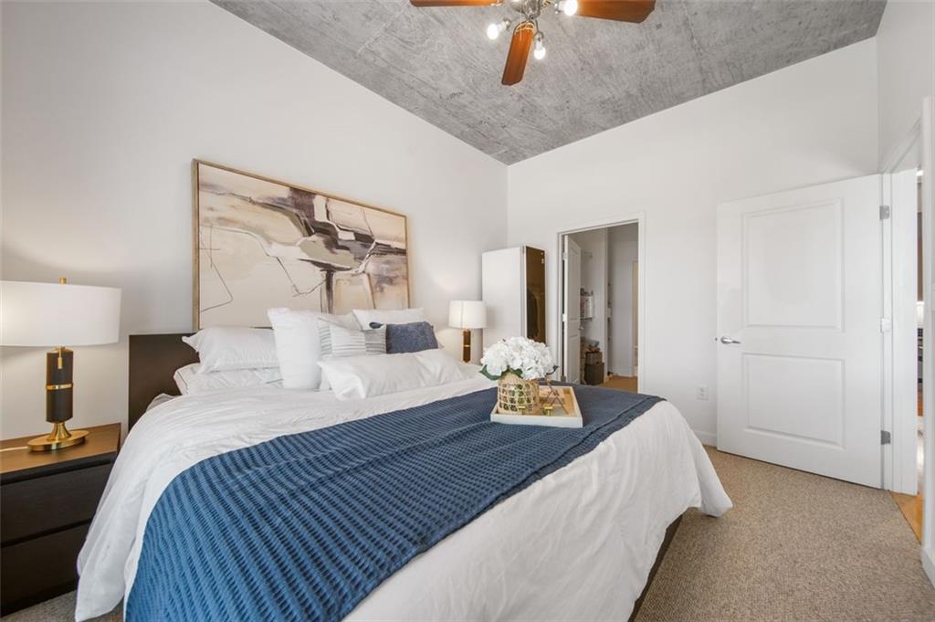 250 Pharr Road Northeast, Unit 412 Atlanta, GA 30305 - Photo 13 of 49 a bedroom with a bed and a chandelier