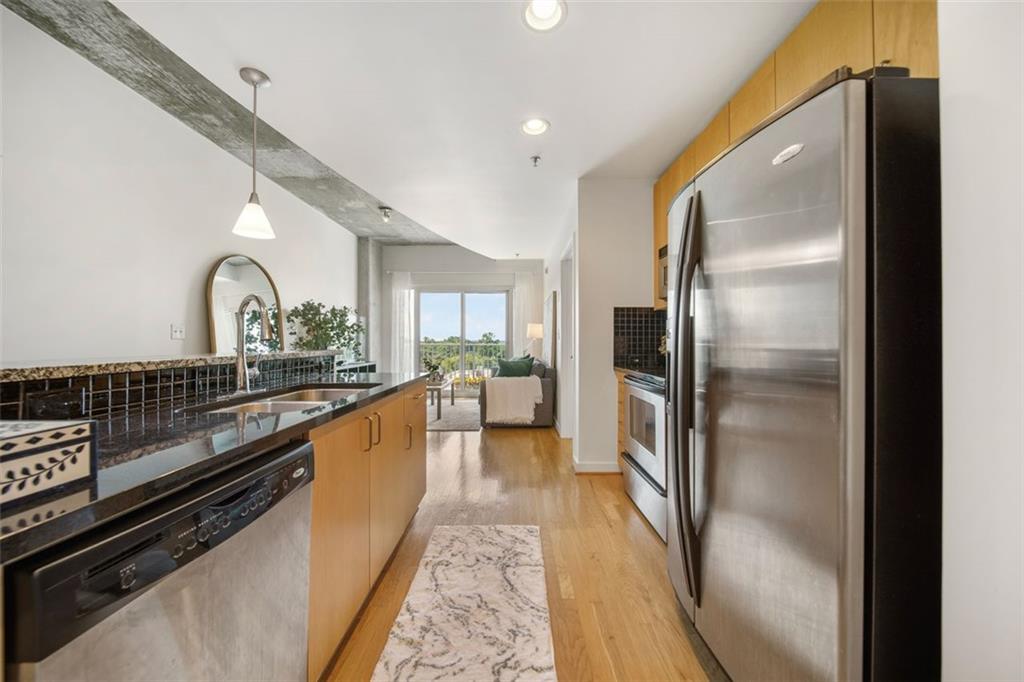 250 Pharr Road Northeast, Unit 412 Atlanta, GA 30305 - Photo 16 of 49 a large kitchen with stainless steel appliances kitchen island granite countertop a refrigerator and a stove top oven
