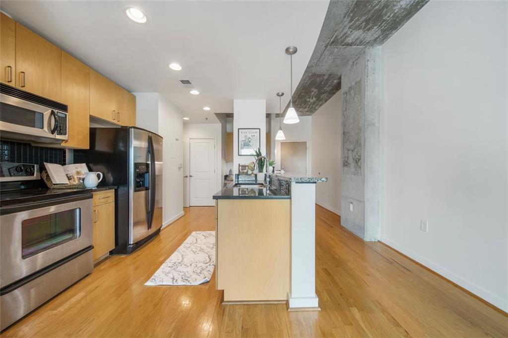 250 Pharr Road Northeast, Unit 412 Atlanta, GA 30305 - Photo 17 of 49 a kitchen with stainless steel appliances granite countertop a refrigerator a stove and a wooden floors