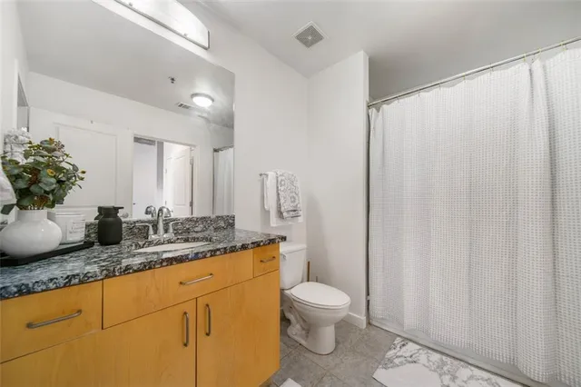 a bathroom with a granite countertop sink toilet and shower